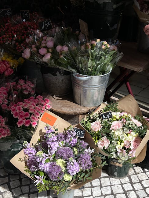 A display of fresh floral arrangements at Elm Park florist showcasing a variety of flower bouquets. In the foreground, a bouquet wrapped in brown paper features purple and lavender flowers, including 
